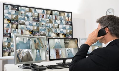35943421_m 35943421 - security system operator looking at cctv footage while talking on telephone